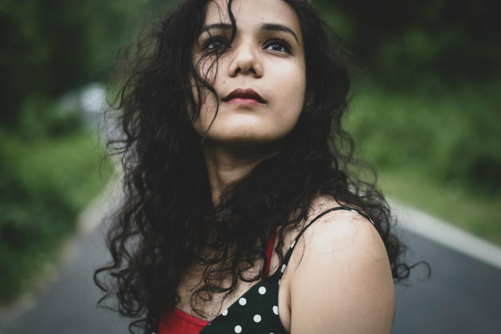 Portrait photo of a woman standing on the road looking up